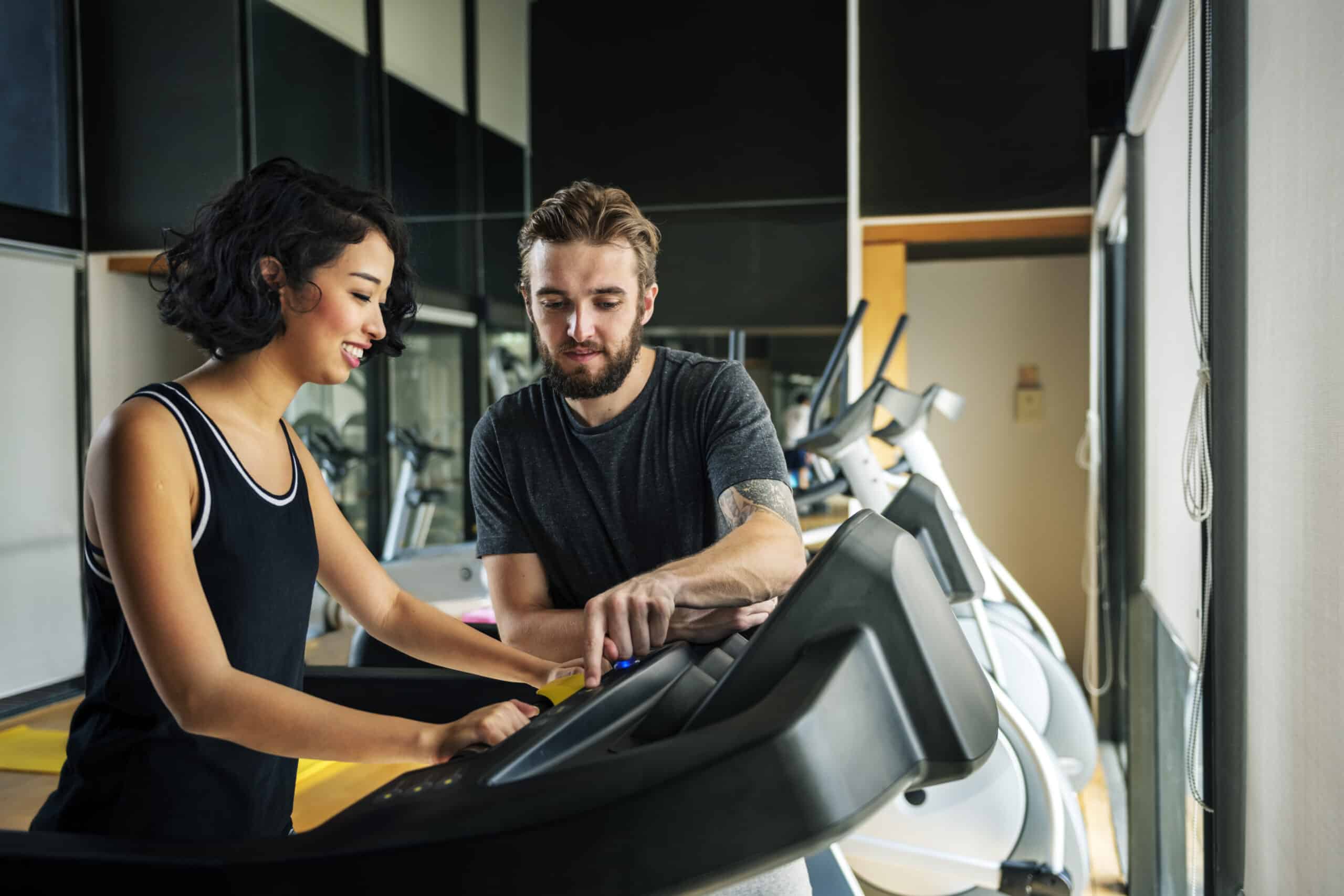 Entrenador configurando la pantalla de la maquinaria de gimnasio.